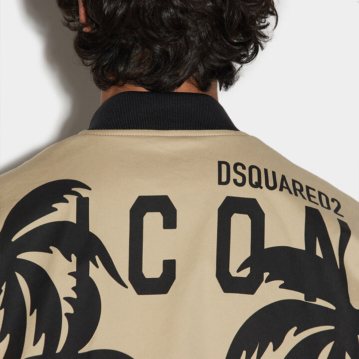 Man turned with an beige and black sweatshirt with dsquared2 icon logo and palms 