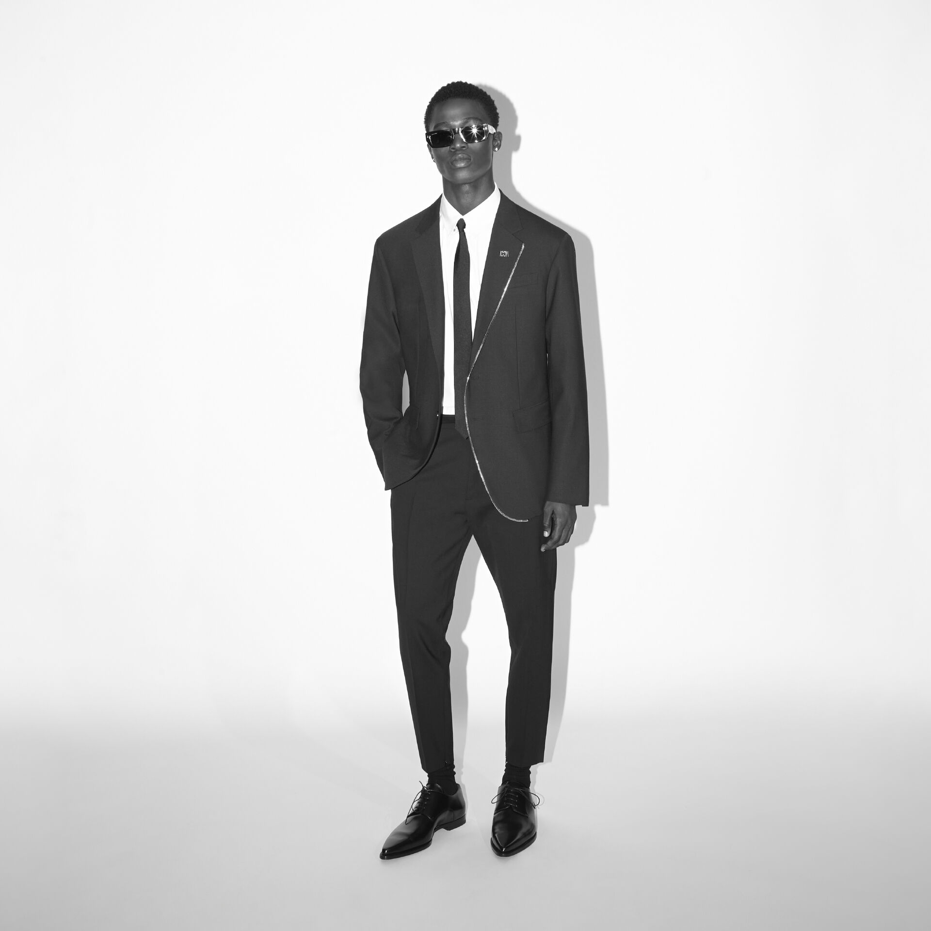 Picture of black and white of man wearing a suit and tie with black sunglasses