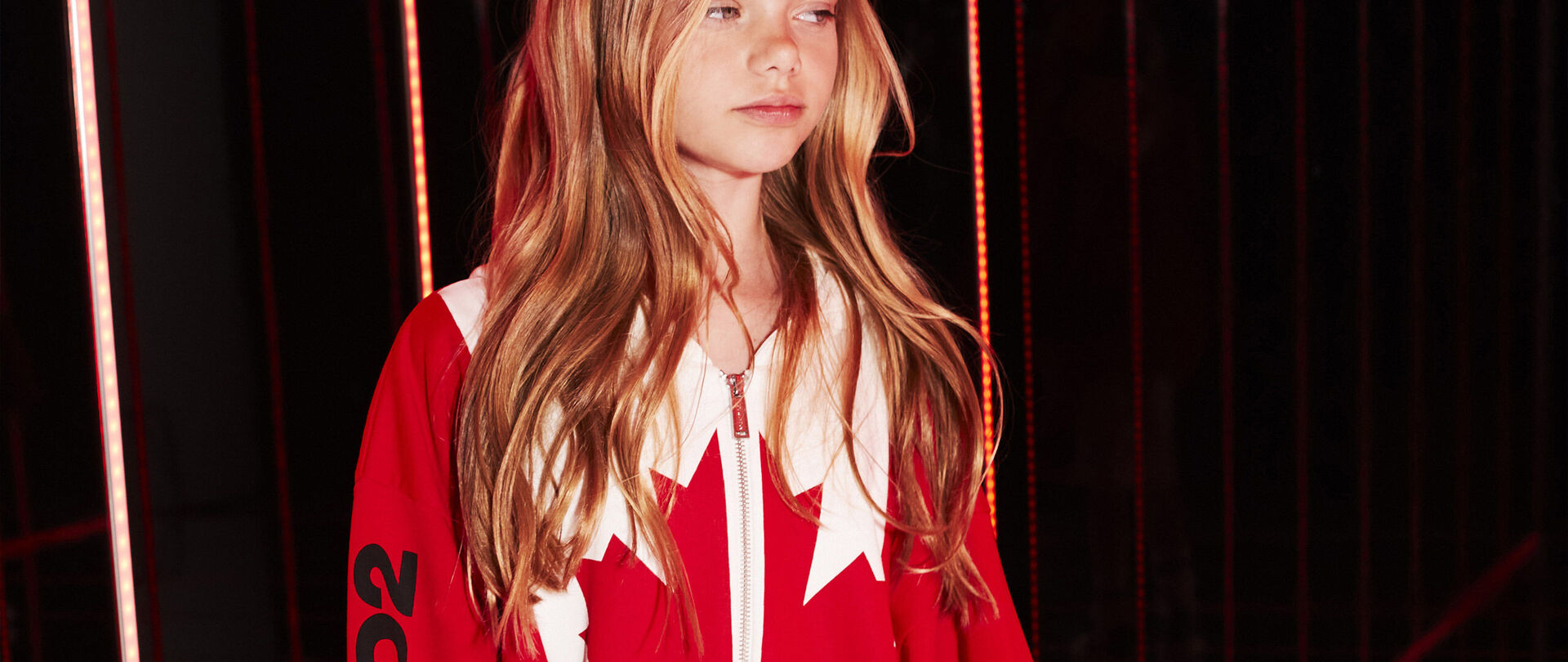 Girl with blonde long hair and red and white sweatshirt with canadian leaf 